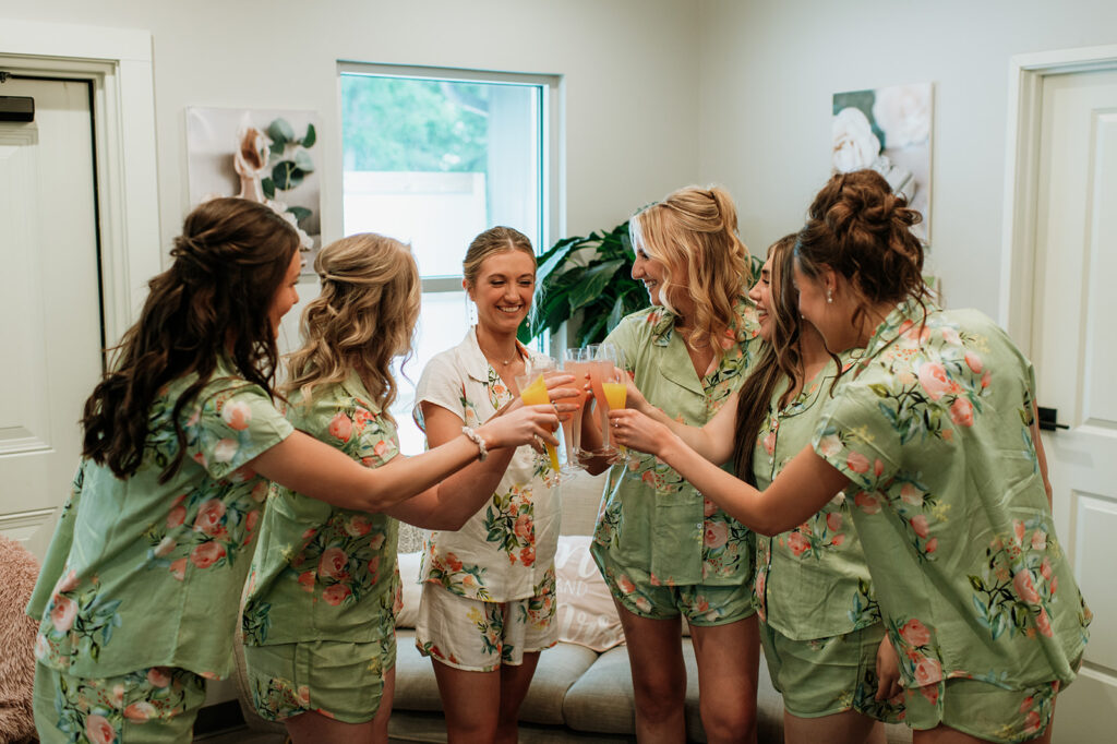 Bride and her bridesmaids toasting with mimosas