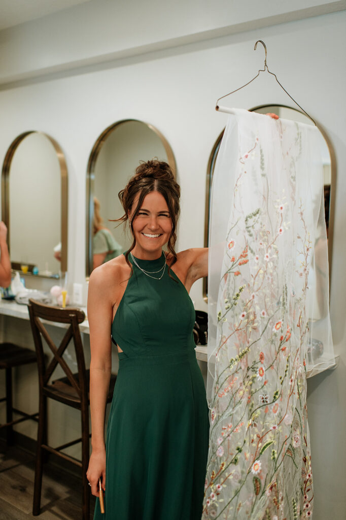 Bridesmaid holding up the brides wildflower cape veil