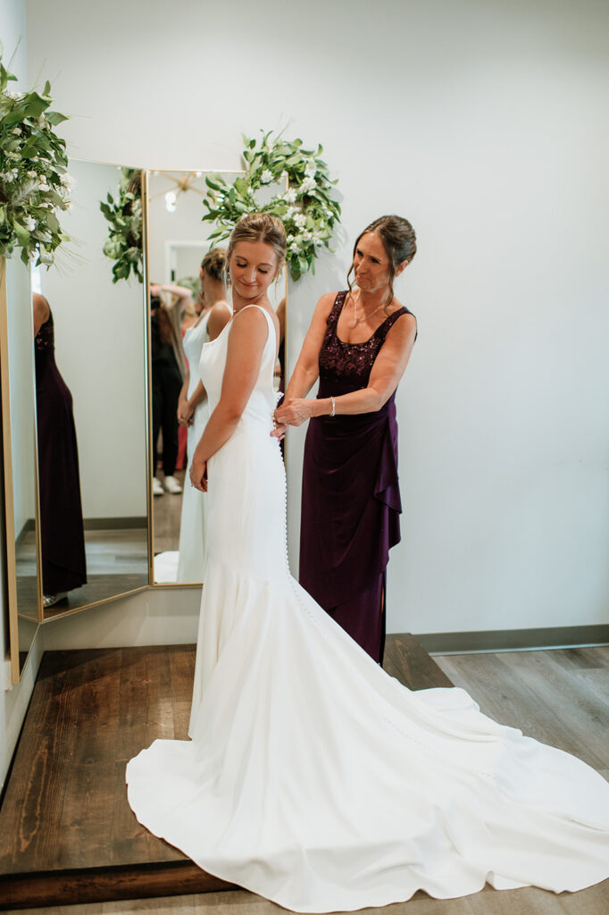 Brides mother helping her get ready for her wedding