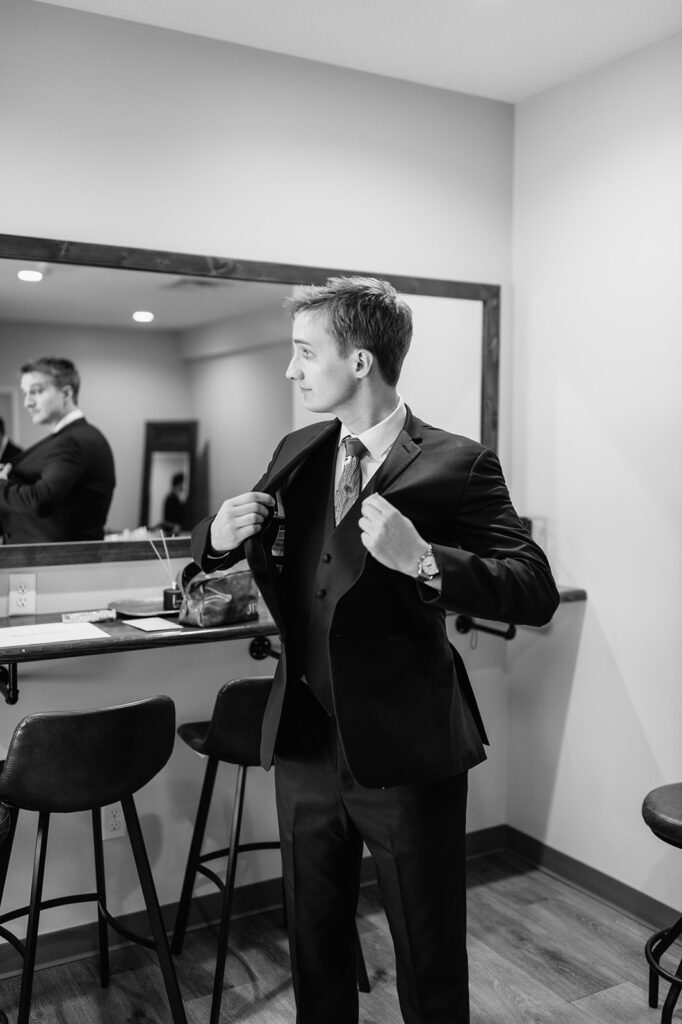 Black and white photo of a groom getting ready in the grooms suite at The Wooded Knot wedding venue in Tippecanoe, Indiana