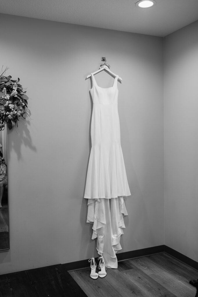 Black and white photo of the brides dress hanging