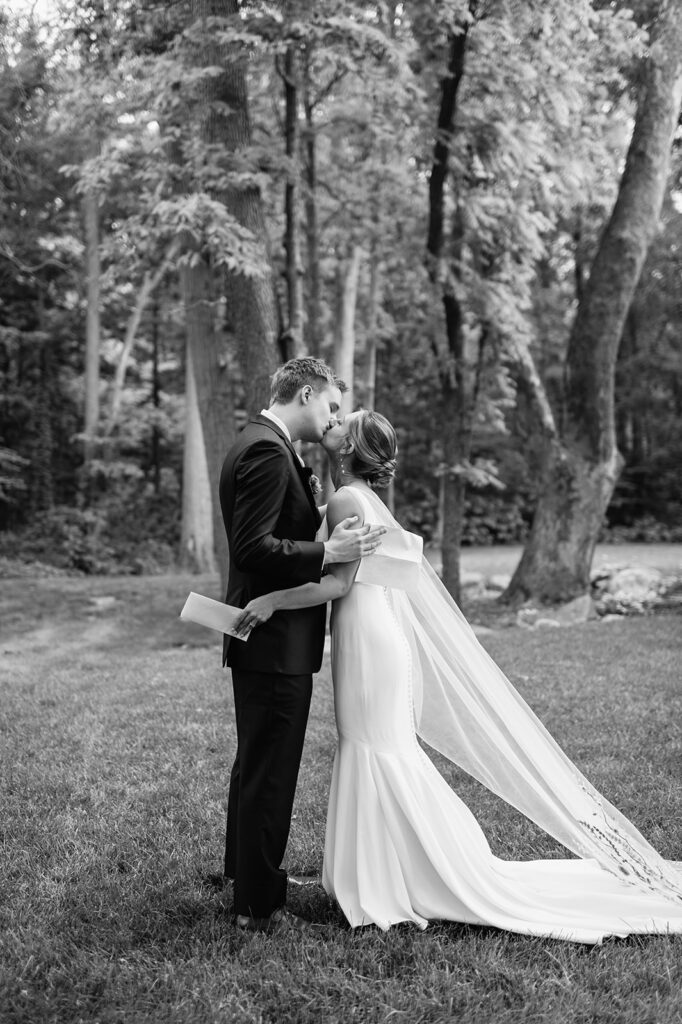 Black and white photo of a bride and groom kissing after sharing private vows