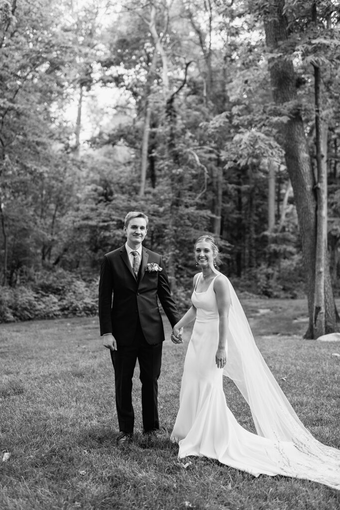 Black and white photo of a bride and groom holding hands after sharing vows