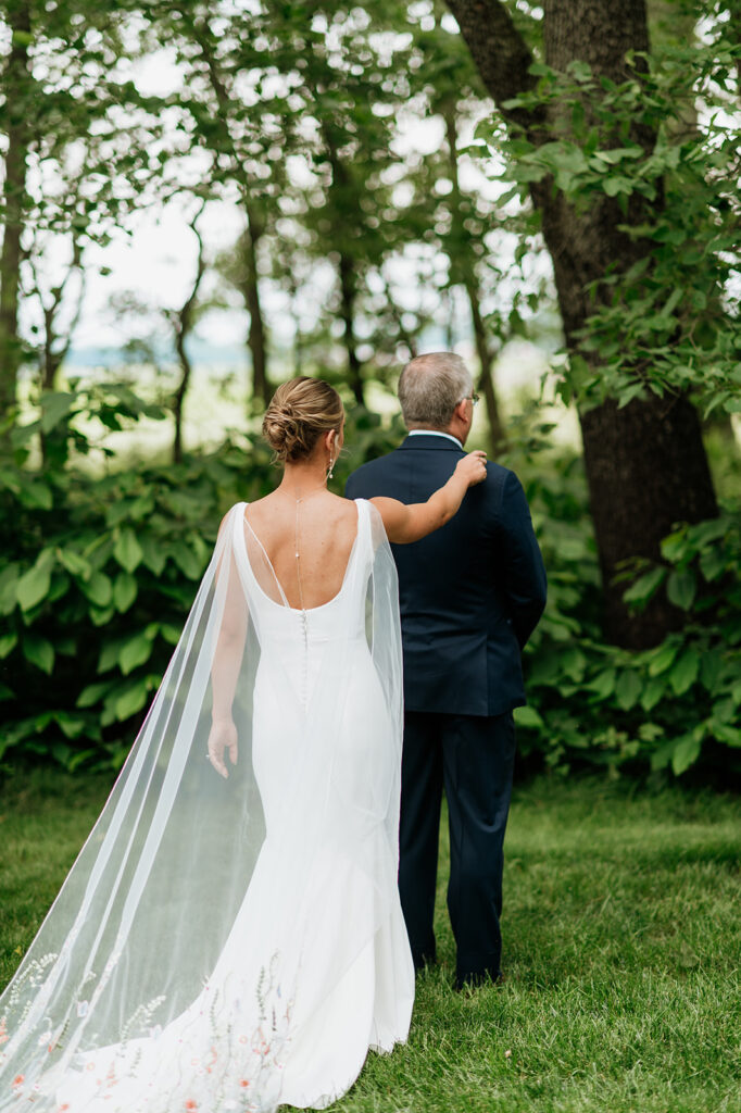 Bride tapping her father on the shoulder for a first look