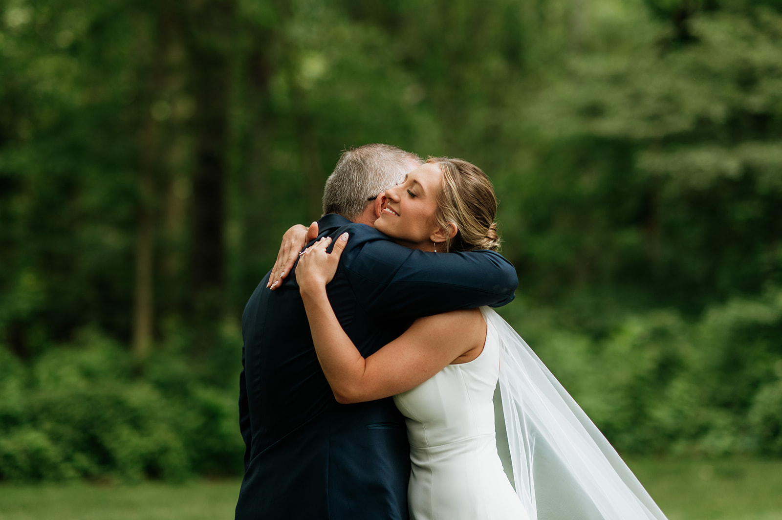 Bride sharing an emotional first look with her father outside