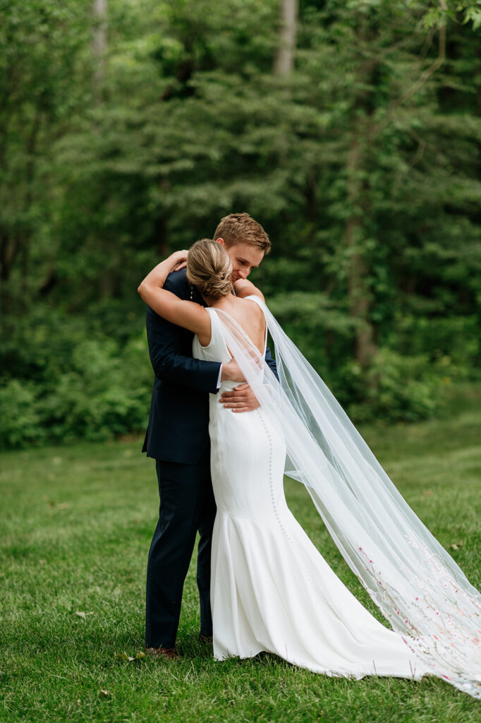 Bride and groom sharing an emotional first look outside