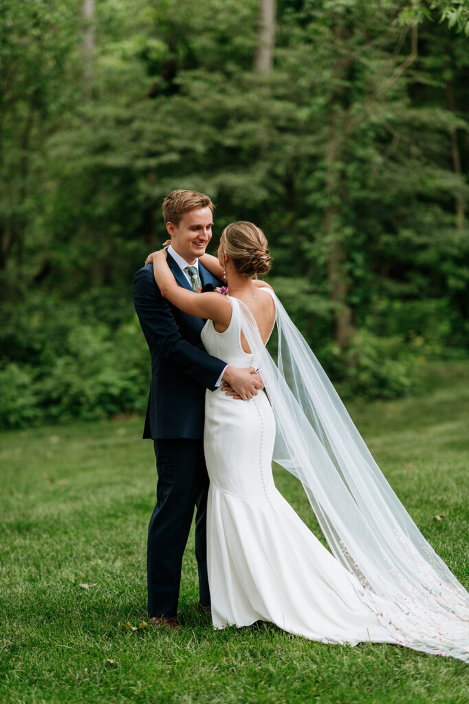 Bride and groom sharing an emotional first look outside