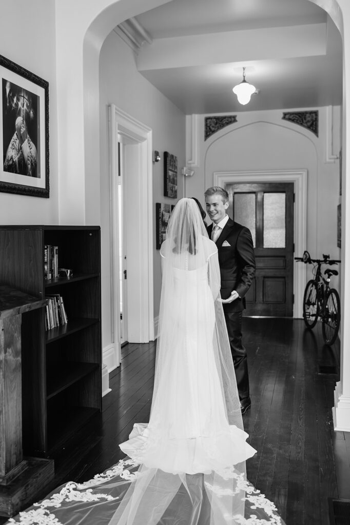 Black and white photo of a bride and groom sharing their first look 