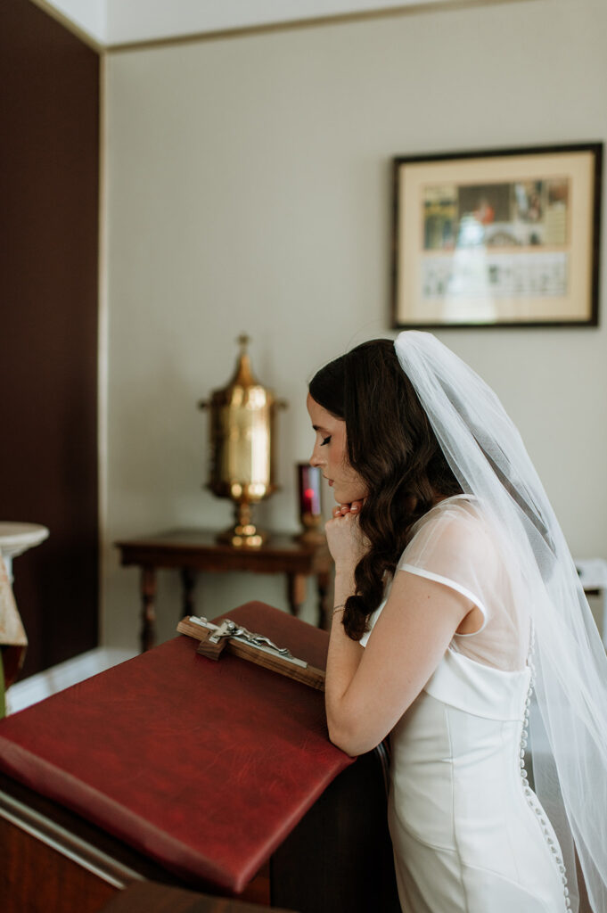 Bride praying before her St. John the Evangelist Catholic Church wedding ceremony in Indianapolis, Indiana