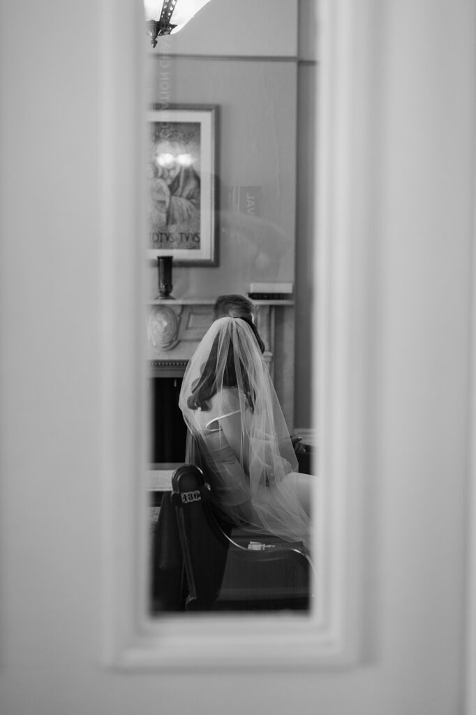 Black and white photo of a bride and groom praying before their St. John the Evangelist Catholic Church wedding ceremony in Indianapolis, Indiana