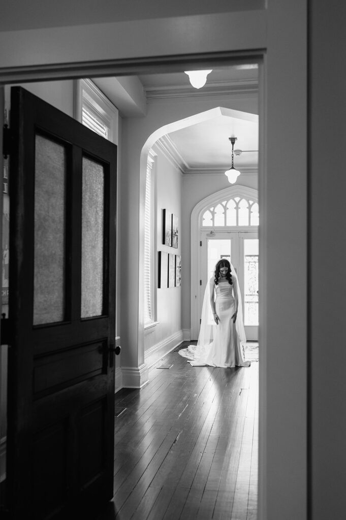 Black and white photo of a bride waiting to share her first look with her groom