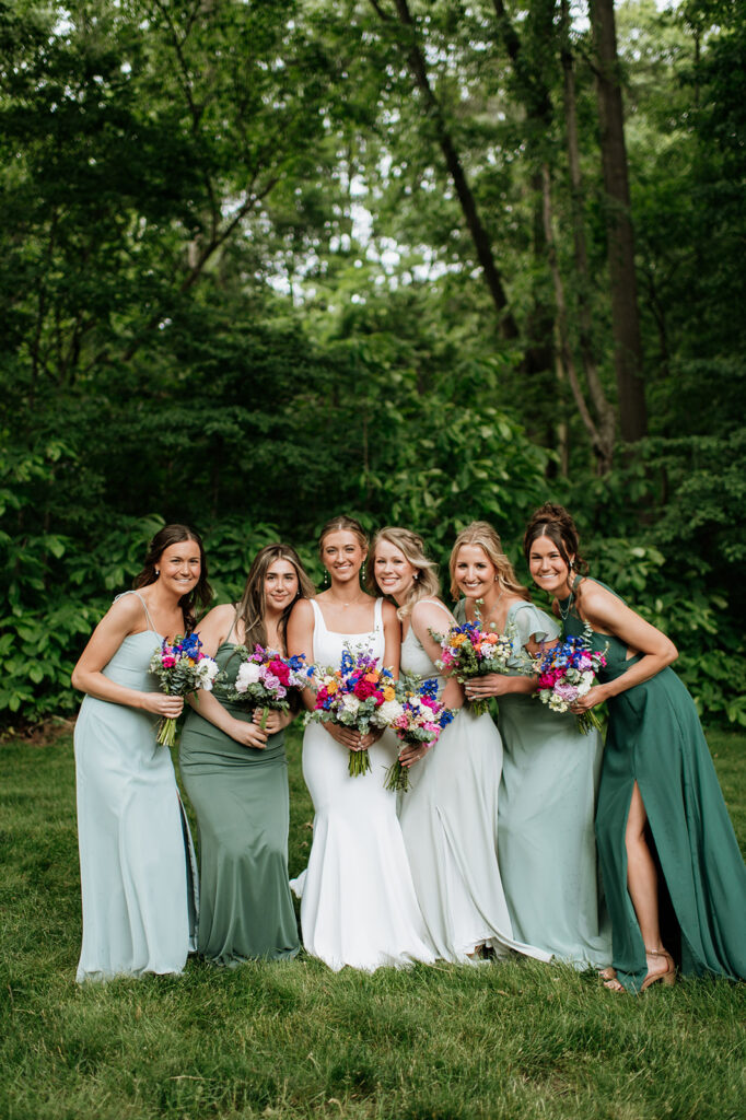 Outdoor bride and bridesmaids photos from a colorful wildflower wedding at The Wooded Knot in Tippecanoe, Indiana