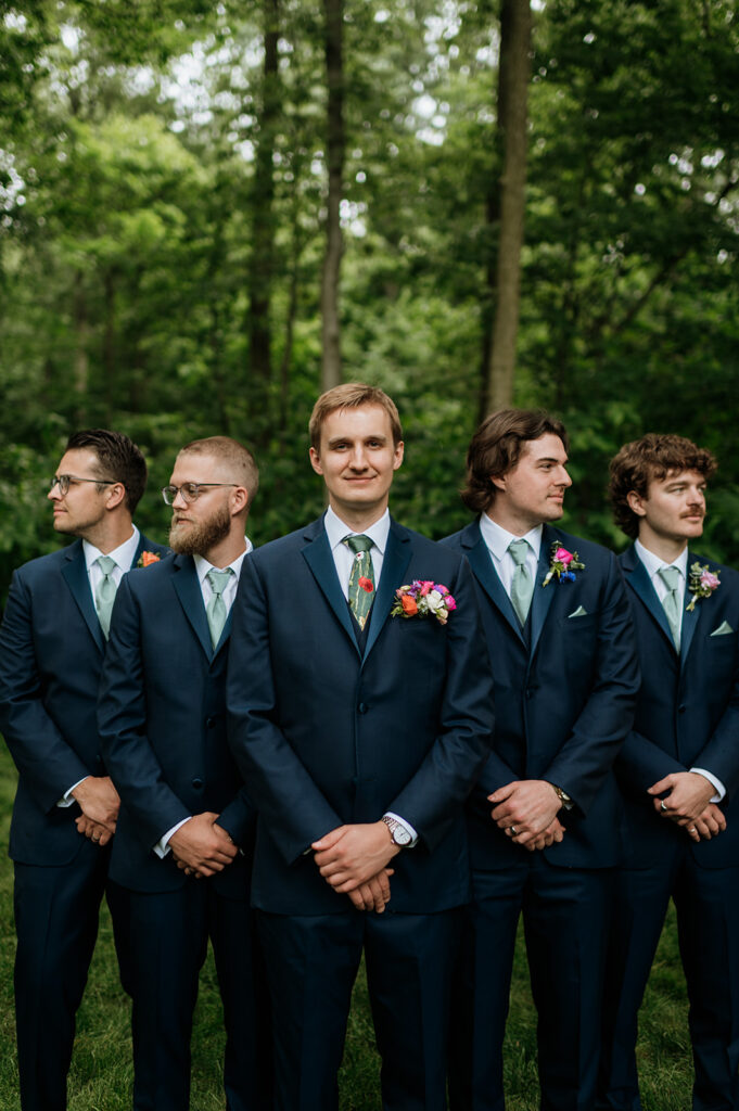 Outdoor groom and groomsmen photos from a colorful wildflower wedding at The Wooded Knot in Tippecanoe, Indiana