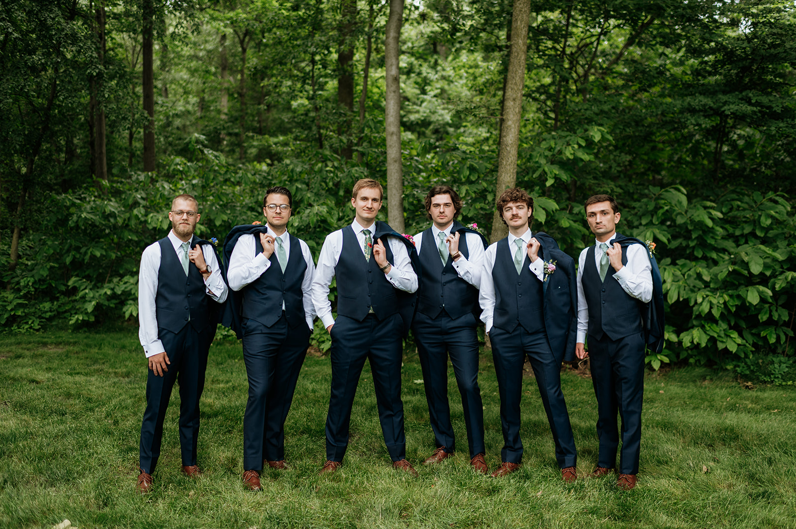 Outdoor groom and groomsmen photos from a colorful wildflower wedding at The Wooded Knot in Tippecanoe, Indiana