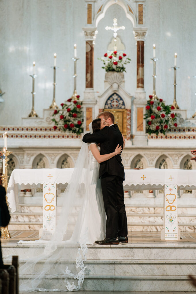 Bride and groom hugging during their St. John the Evangelist Catholic Church wedding ceremony in Indianapolis, Indiana