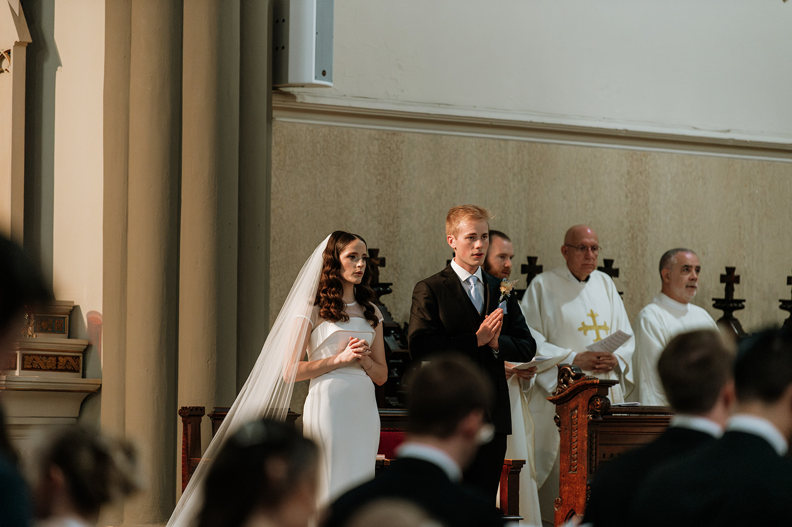 Bride and groom praying during their St. John the Evangelist Catholic Church wedding ceremony in Indianapolis, Indiana