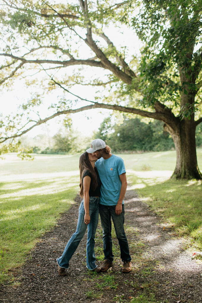 Couple kissing during their woodsy outdoor Midwest engagement photos in Albion, Indiana