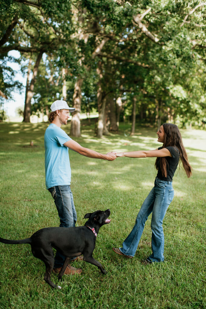 Man and woman being playful during their woodsy Midwest engagement photos in Albion, Indiana