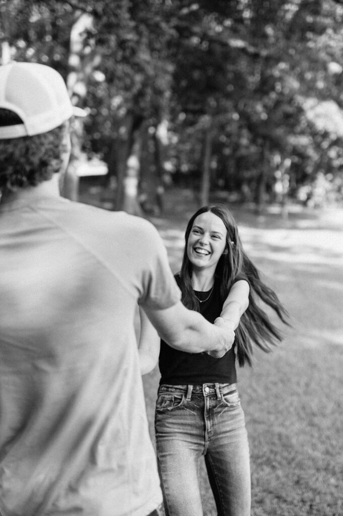 Black and white photo of a couple spinning around during their engagement shoot