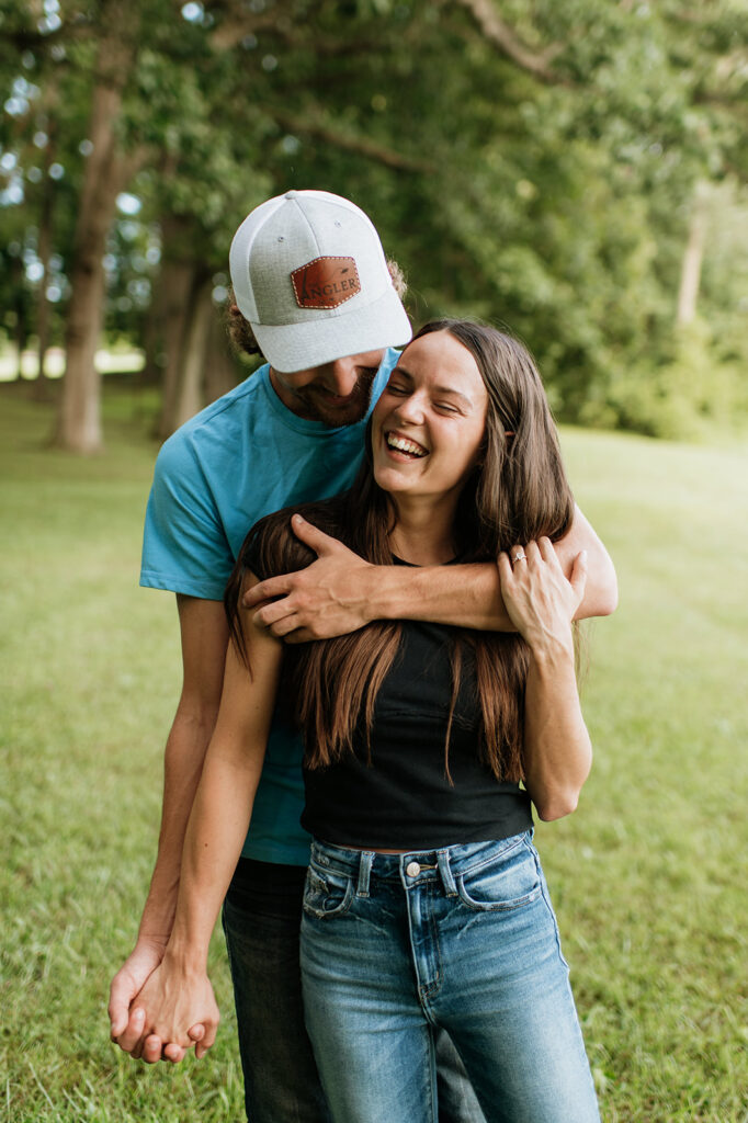 Man and woman laughing during their playful woodsy Midwest engagement photos