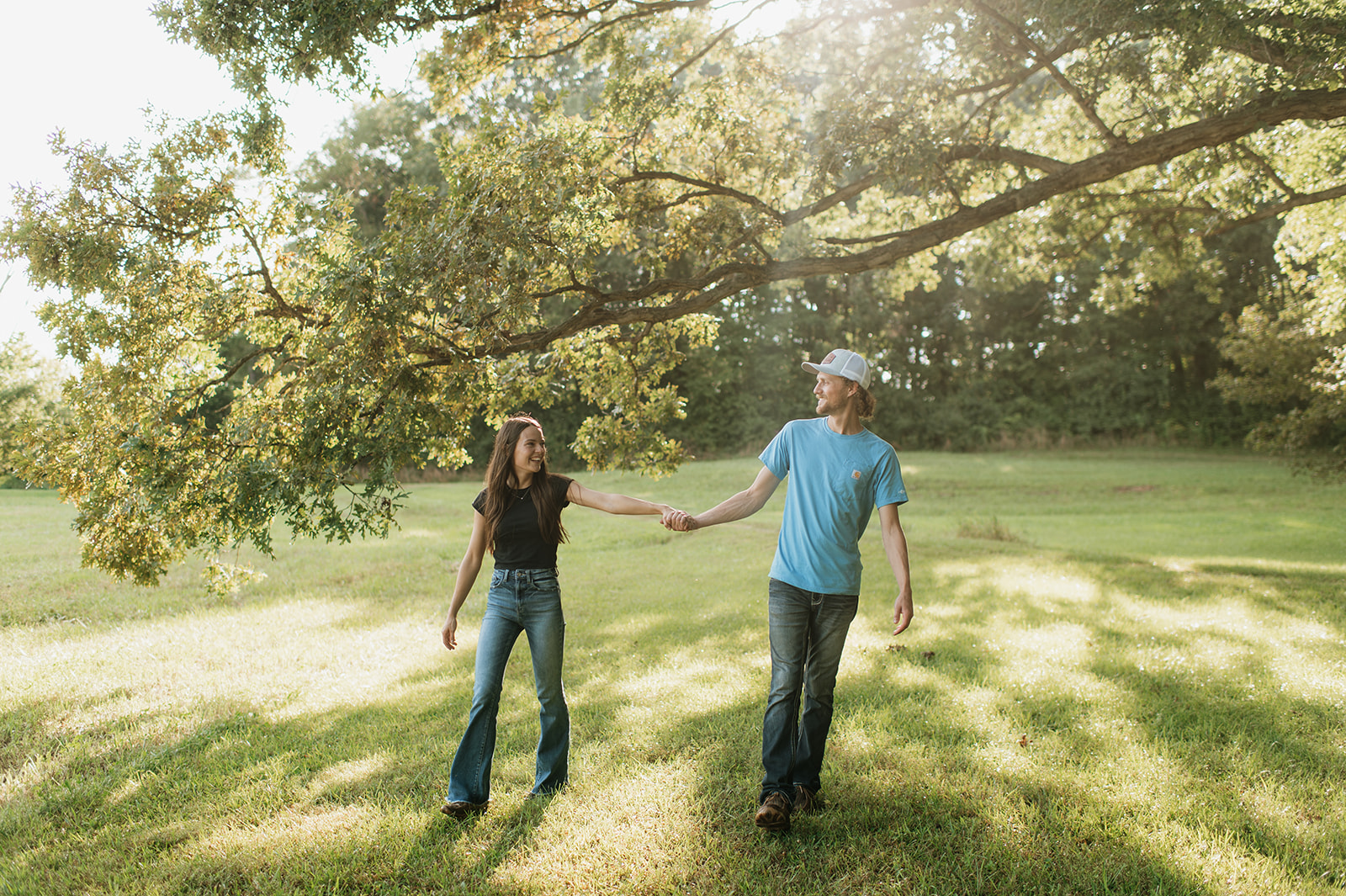 Man and woman holding hands as they walk outdoors for their Midwest engagement photos in Albion, Indiana