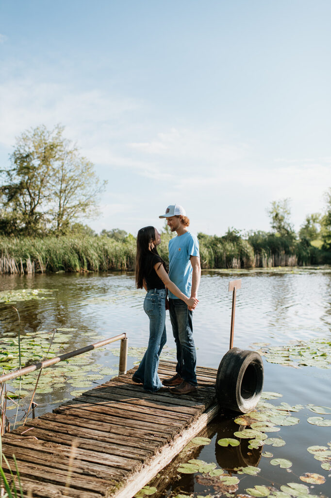 Man and woman standing on a deck over a pond