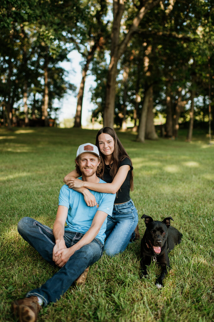 Man and woman posing with their dog for their engagement shoot in Albion, Indiana