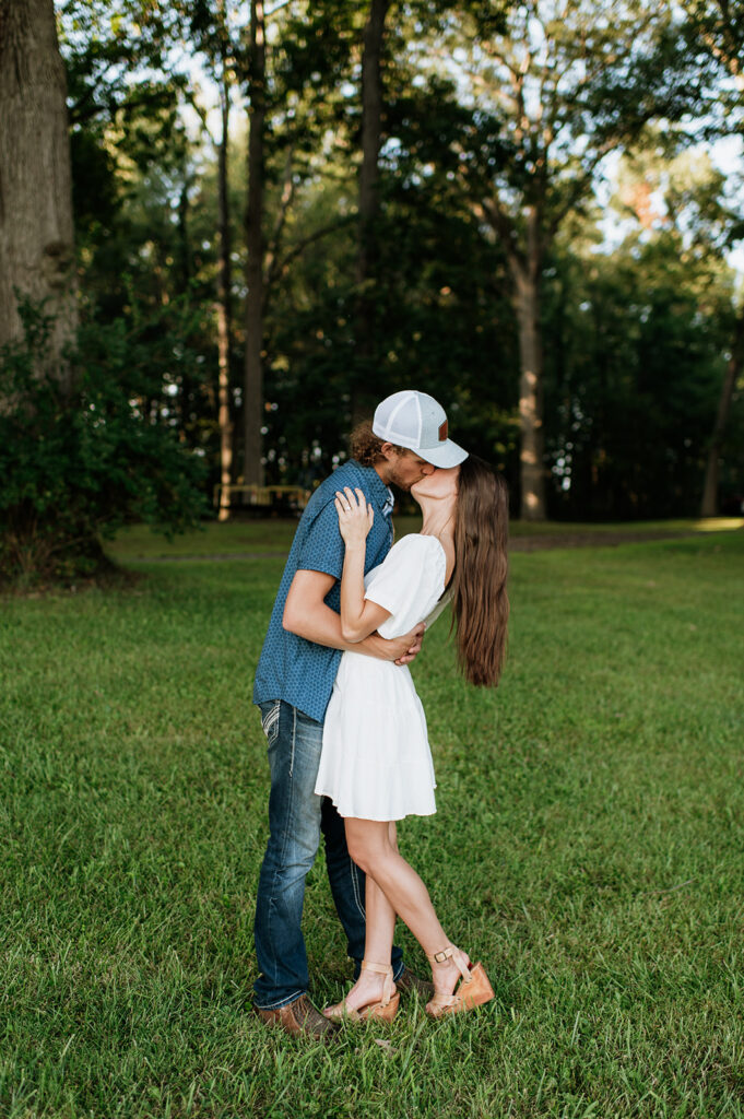 Man and woman kissing during their outdoor Midwest engagement photos