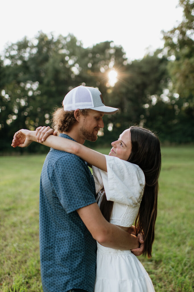 Man and woman holding each other during their golden hour engagement session in the Midwest