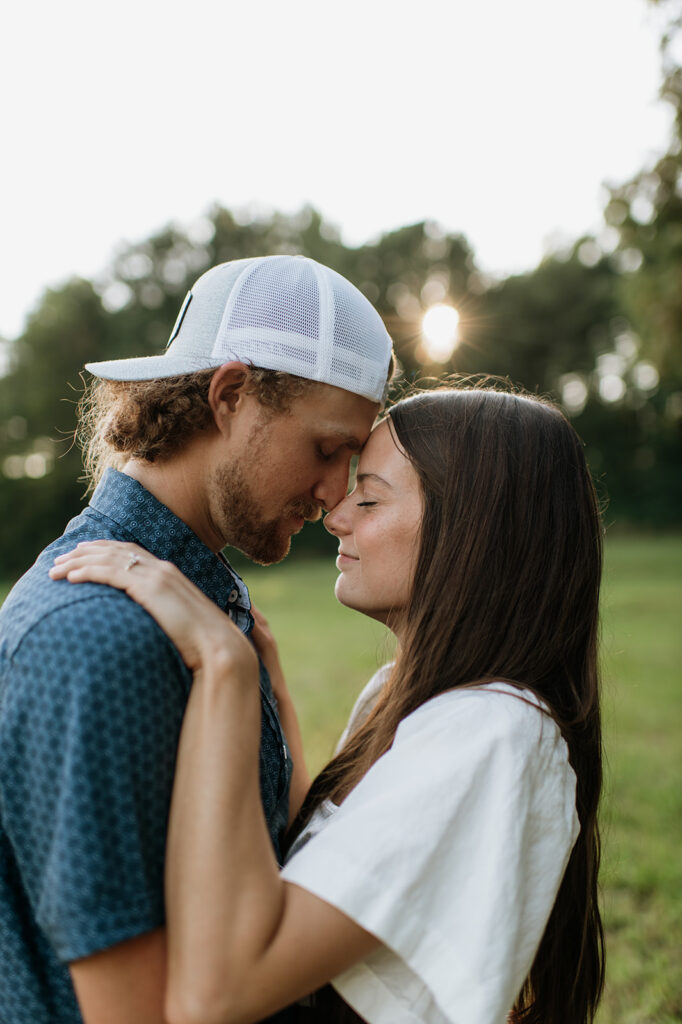 Man and woman touching noses during their golden hour engagement session in Albion, Indiana