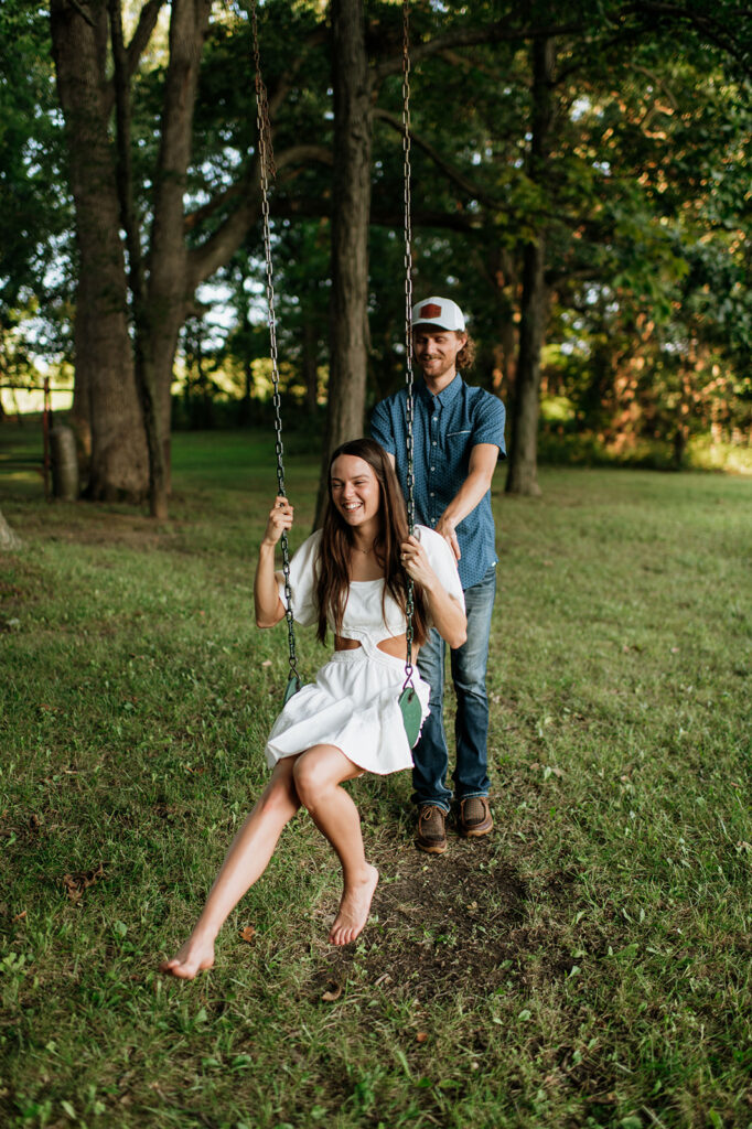 Man pushing his fiancé on a swing