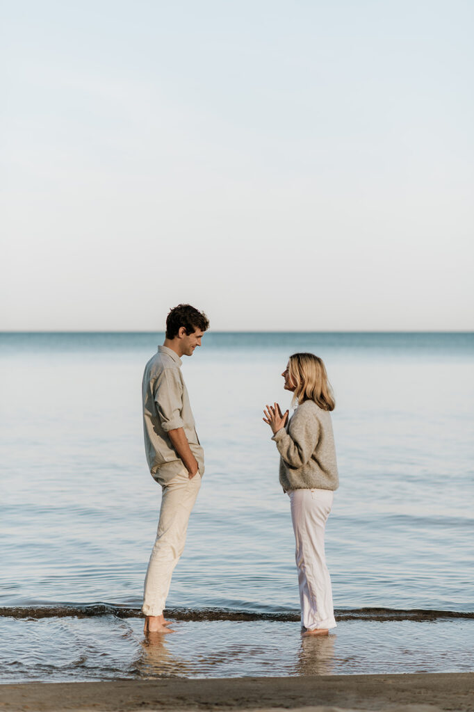 Man and woman talking on Gordon Beach after their Michigan surprise proposal