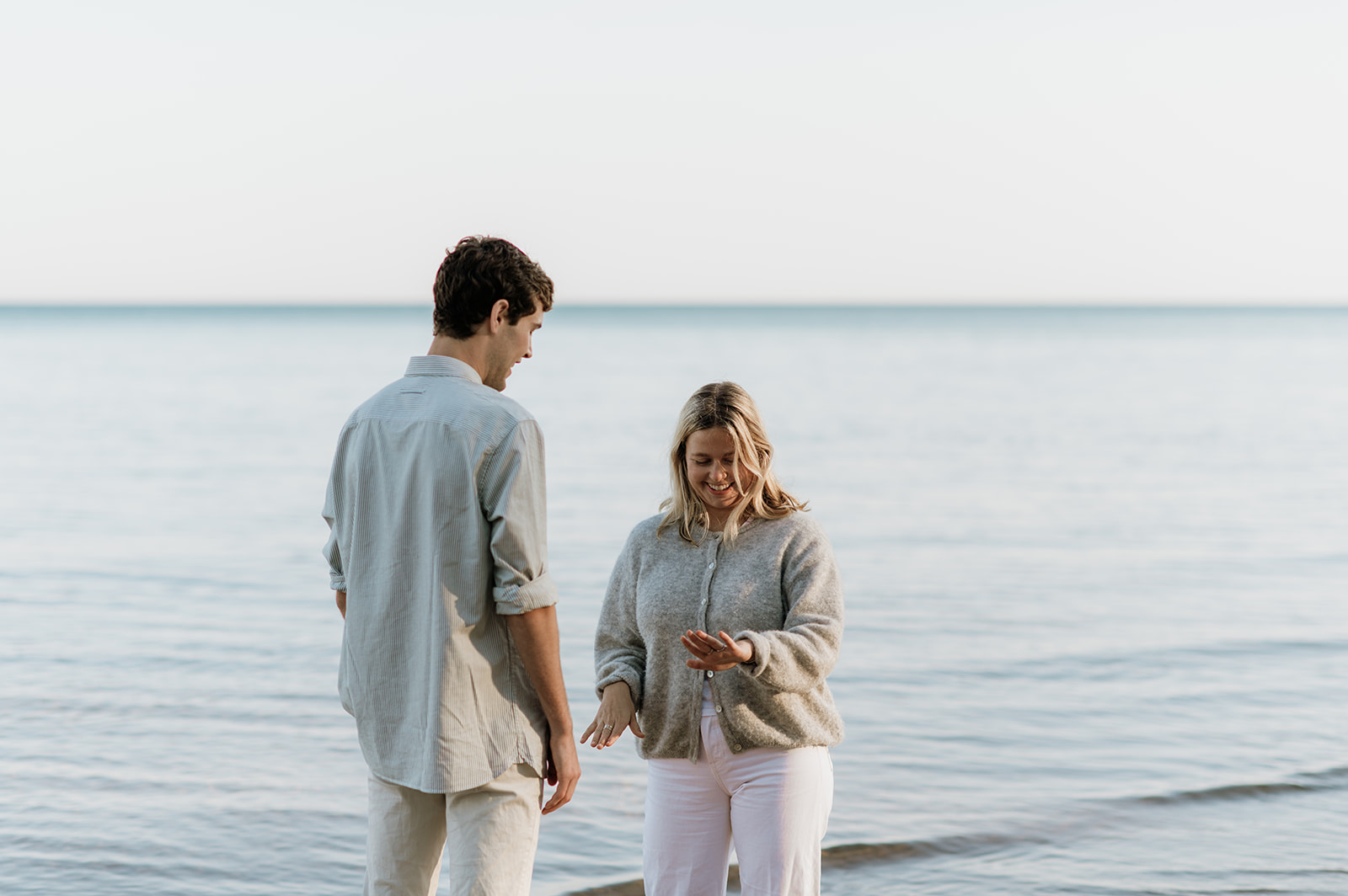 Woman admiring her ring after their Michigan surprise proposal on Gordon Beach