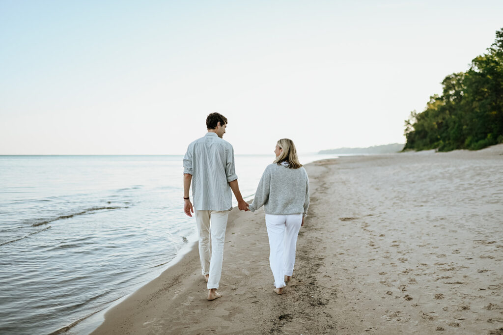 Man and woman holding hands as they walk Gordon Beach in New Buffalo Michigan