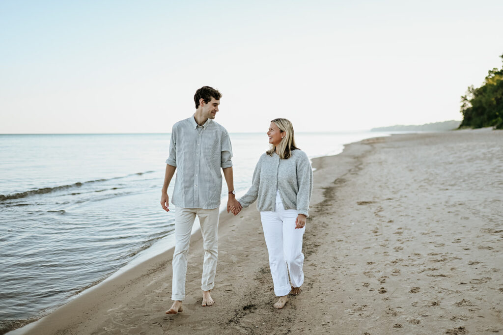 Man and woman holding hands as they walk Gordon Beach in New Buffalo Michigan