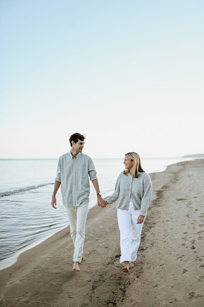 Man and woman holding hands and walking on Gordon Beach