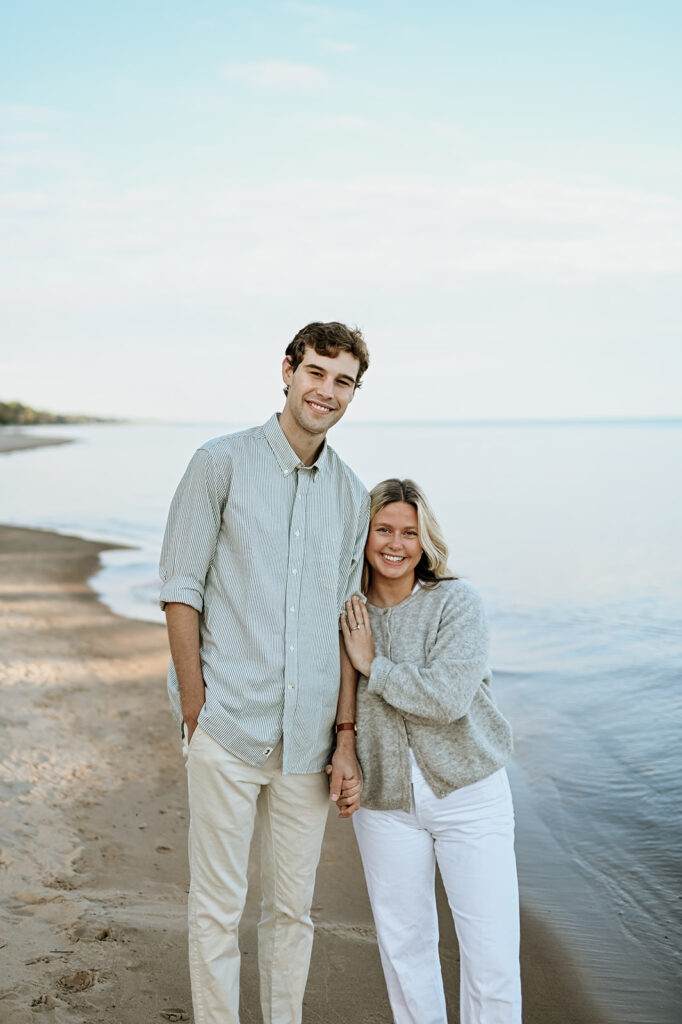 Man and woman posing on Gordon Beach in New Buffalo, Michigan for their engagement photos