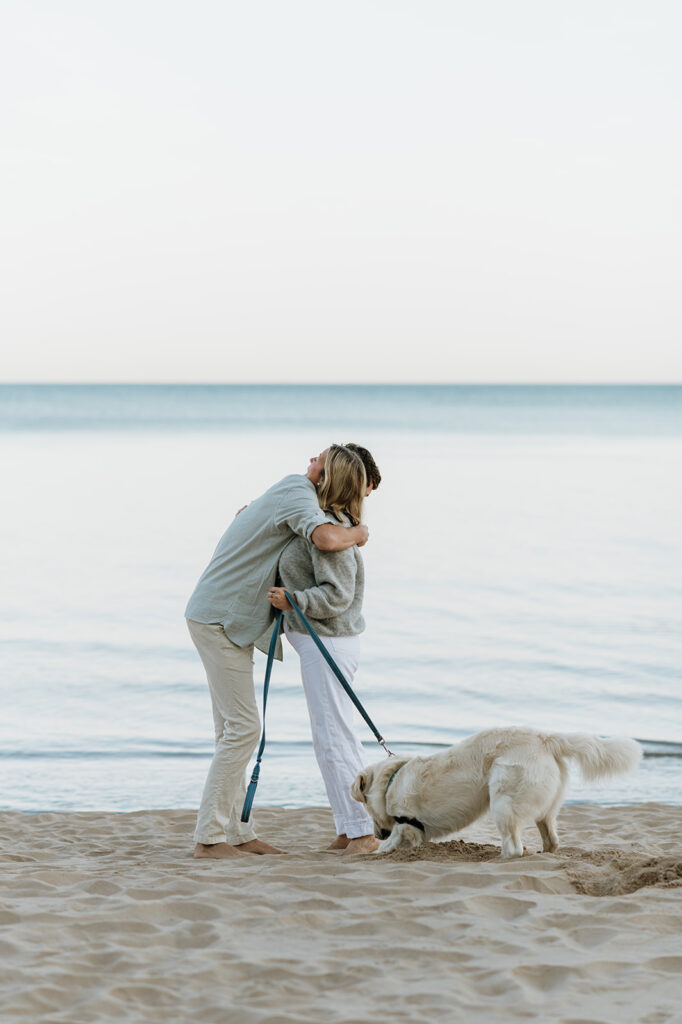 Man and woman hugging after their Michigan surprise proposal on Gordon Beach in New Buffalo