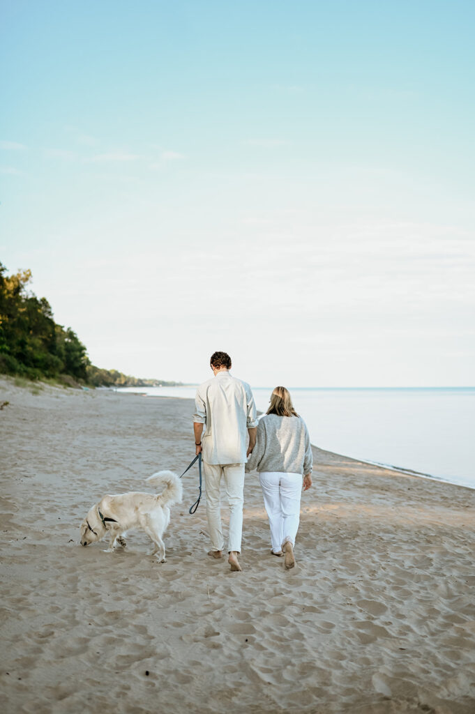 Man, woman and their dog walking Gordon Beach in New Buffalo, Michigan