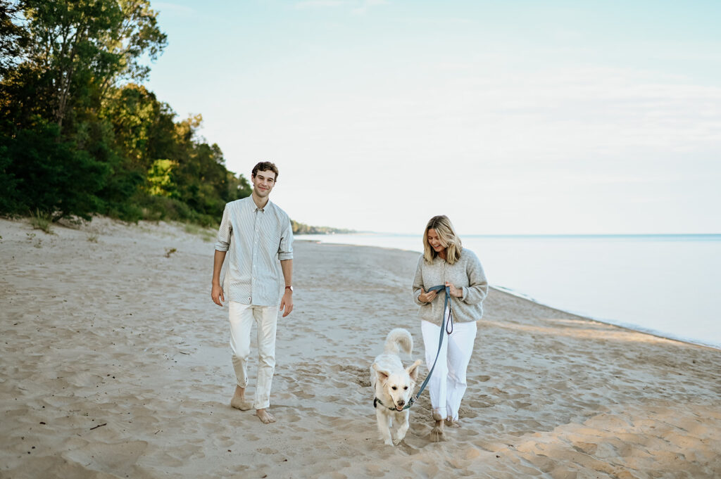 Man, woman and their dog walking Gordon Beach in New Buffalo, Michigan