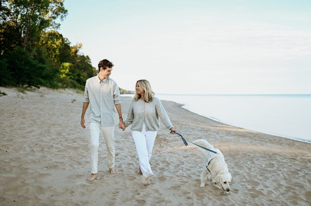 Man, woman and their dog walking Gordon Beach in New Buffalo, Michigan