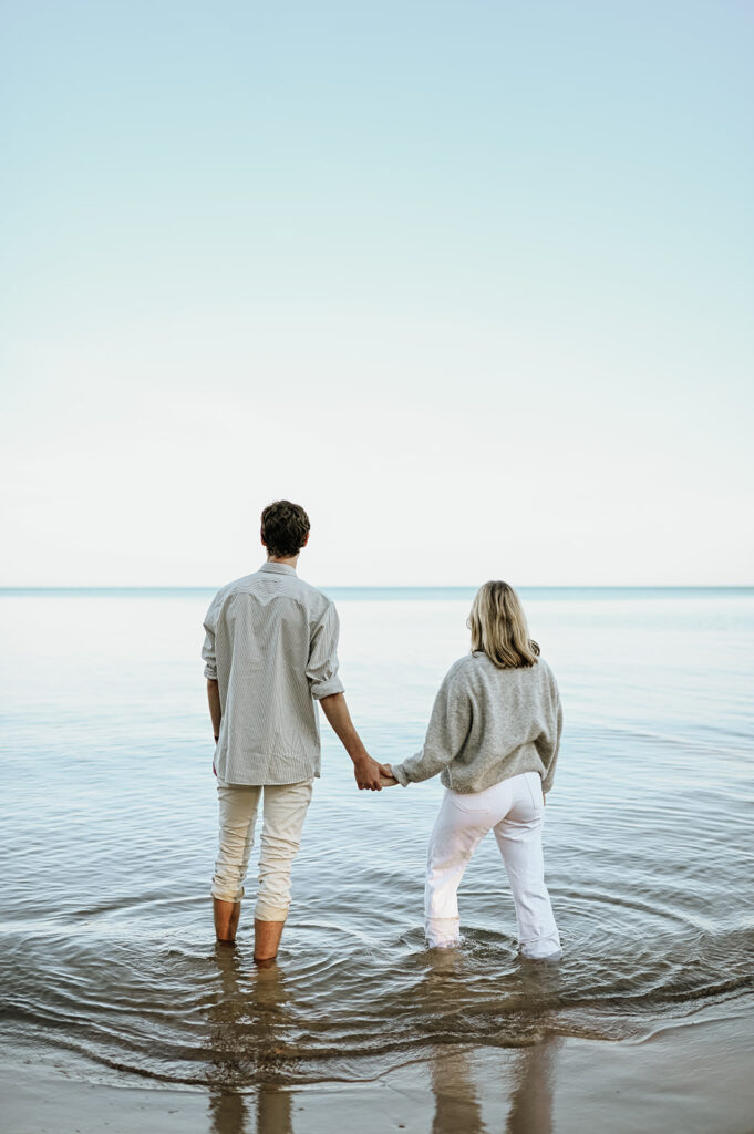 Man and woman posing in the water at Gordon Beach in New Buffalo, Michigan