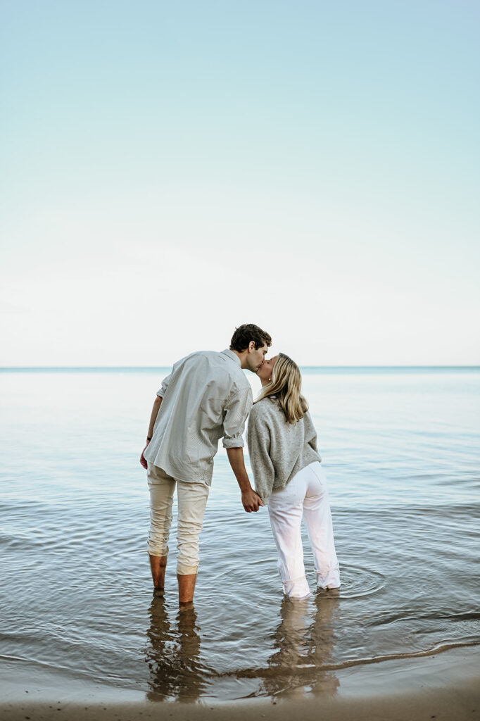 Man and woman kissing while standing in the water at Gordon Beach in New Buffalo, Michigan