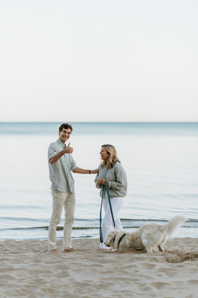 Man signaling a thumbs up after a successful Michigan surprise proposal; at Gordon Beach