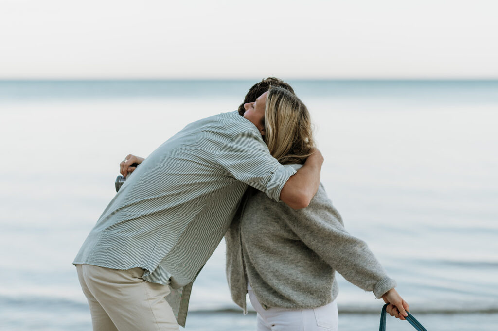 Man and woman hugging after a Michigan surprise proposal