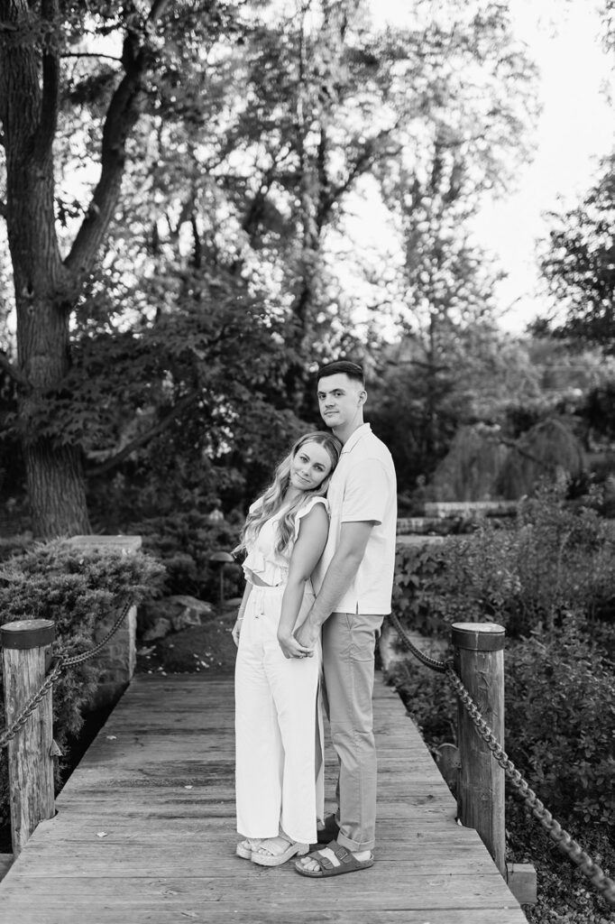 Black and white photo of a couple posing on a dock