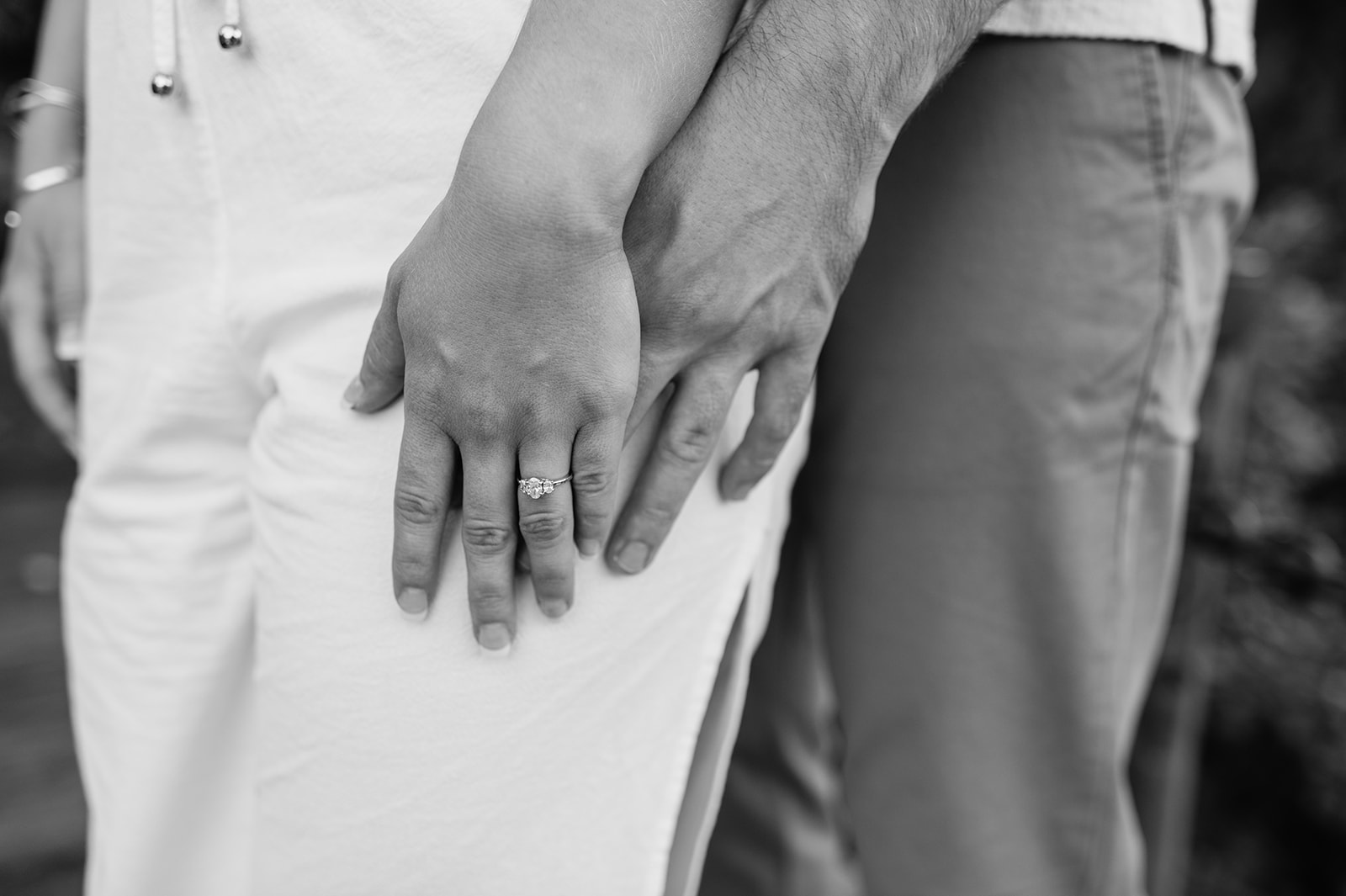 Black and white close up shot of a man and woman holding hands during their engagement shoot