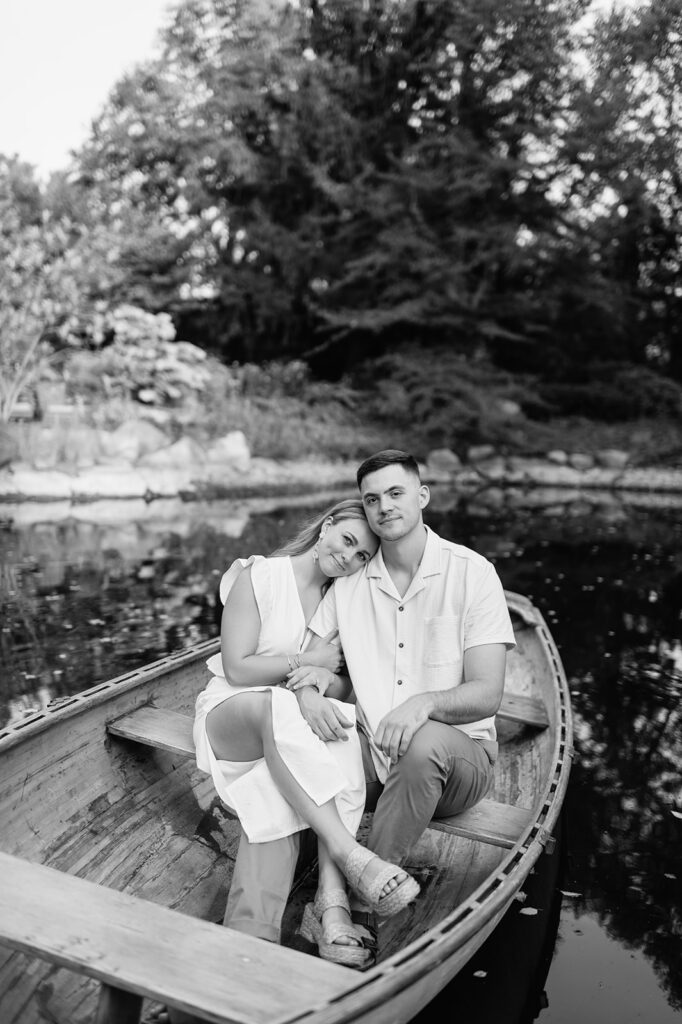 Black and white photo of a couple sitting in a canoe at Hamstra Gardens for their Wheatfield, Indiana engagement photos