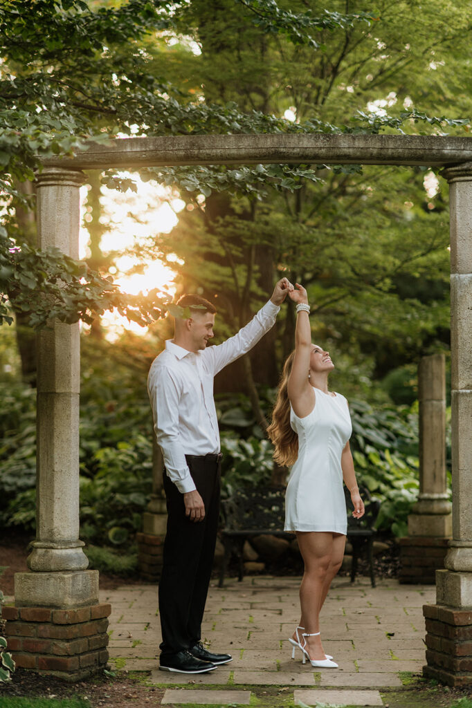 Man twirling his fiancé during their sunset engagement session