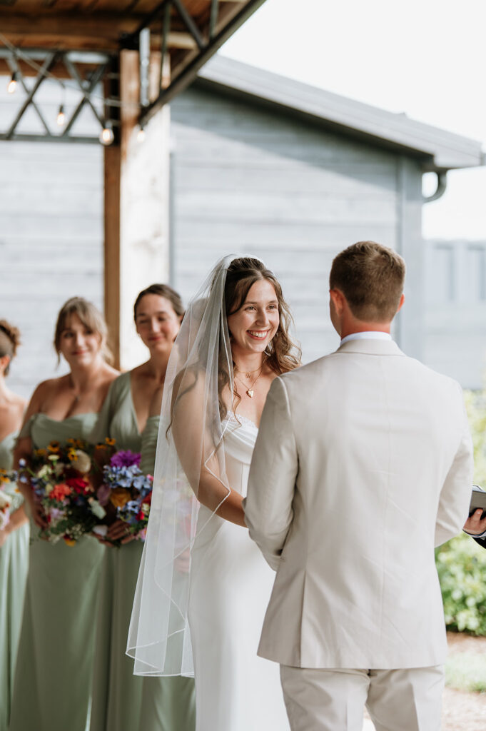 Bride smiling at her groom during their wedding ceremony